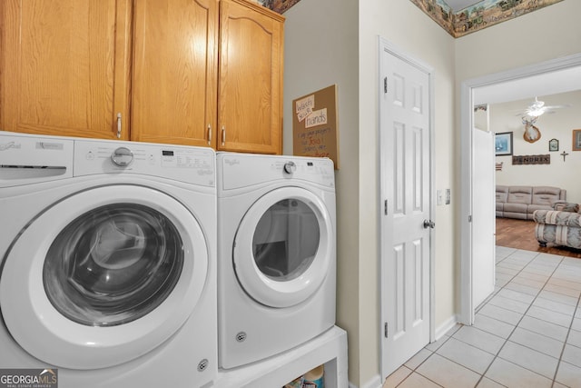 washroom featuring a ceiling fan, washing machine and dryer, cabinet space, and light tile patterned floors