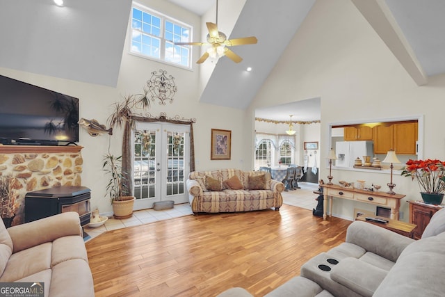 living area with french doors, plenty of natural light, a ceiling fan, and light wood-style floors