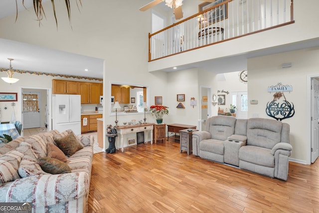 living room featuring light wood-style floors and a ceiling fan