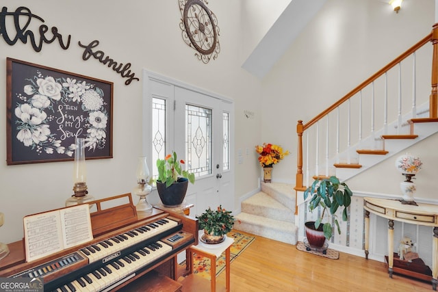 entrance foyer featuring a high ceiling, stairway, and wood finished floors