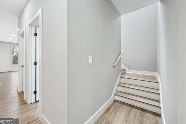 staircase with baseboards, wood finished floors, and recessed lighting