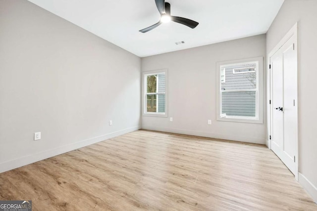 unfurnished bedroom with a ceiling fan, light wood-type flooring, visible vents, and baseboards