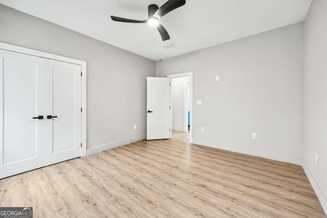 unfurnished bedroom featuring visible vents, light wood-type flooring, a ceiling fan, and baseboards