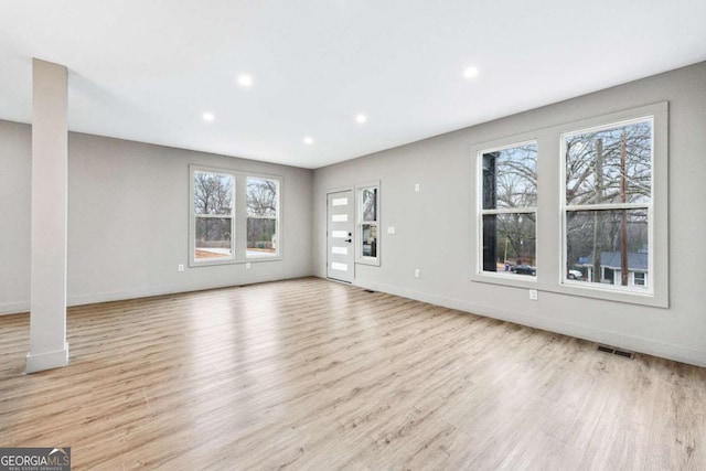 unfurnished living room featuring light wood-type flooring, visible vents, baseboards, and recessed lighting