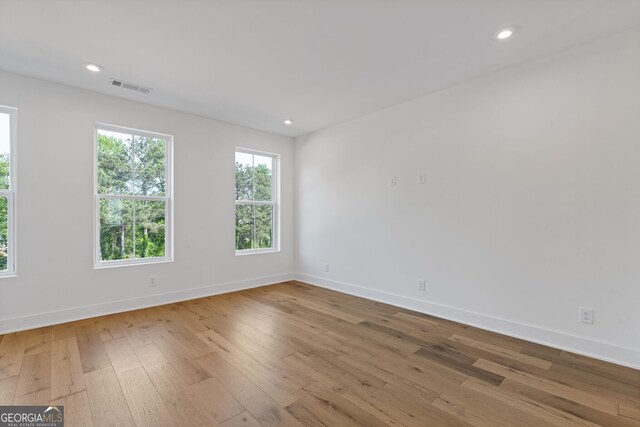 unfurnished room featuring hardwood / wood-style floors, baseboards, and recessed lighting