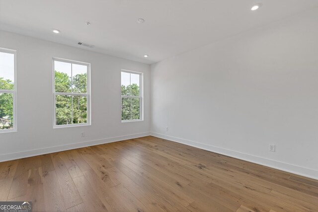 spare room with baseboards, hardwood / wood-style floors, and recessed lighting