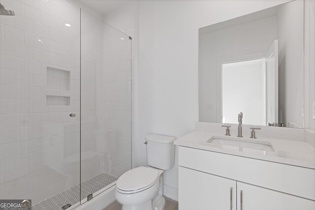 full bathroom featuring toilet, a shower stall, and vanity