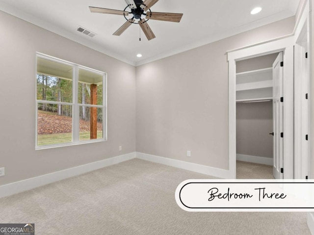 unfurnished bedroom with crown molding, light colored carpet, visible vents, and baseboards