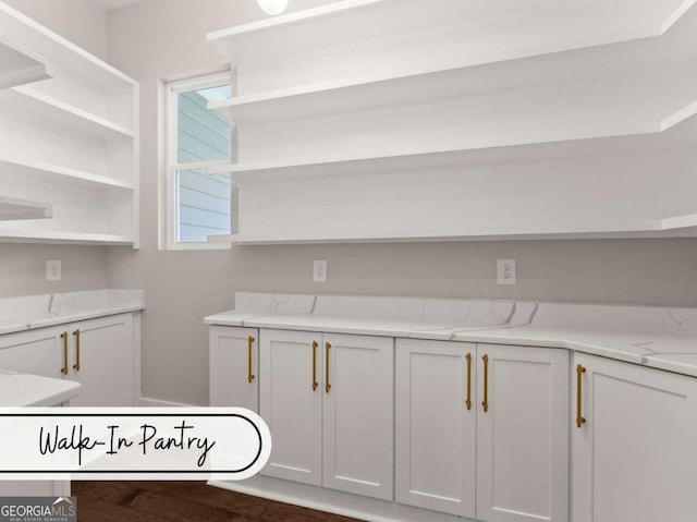 interior space featuring light stone countertops, white cabinetry, and open shelves