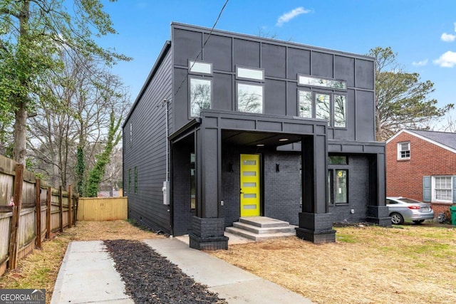 contemporary house featuring fence and brick siding