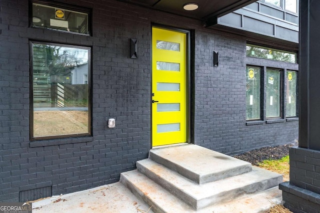 doorway to property featuring brick siding