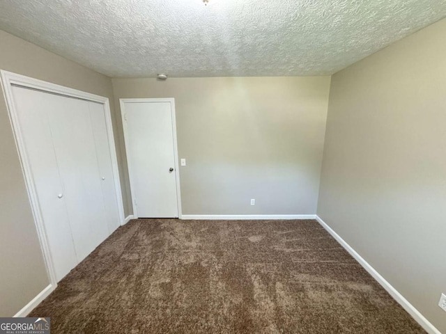 unfurnished bedroom featuring a textured ceiling, a closet, baseboards, and carpet flooring