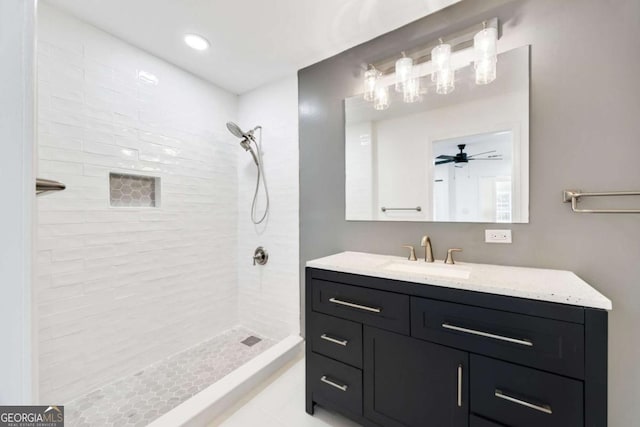 full bath featuring vanity, a ceiling fan, and tiled shower