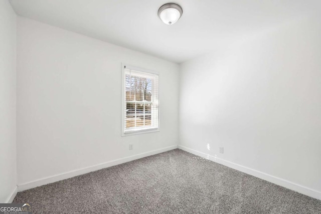 spare room with baseboards and carpet floors