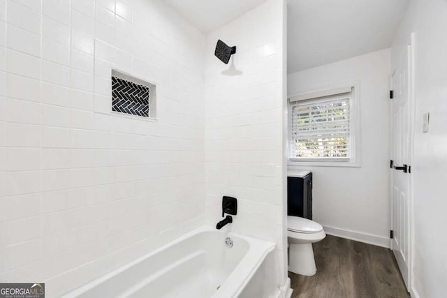 full bath with baseboards, toilet, wood finished floors, and bathing tub / shower combination