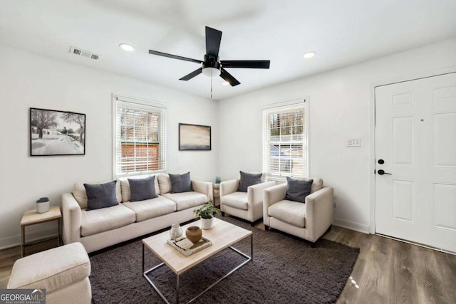 living area with wood finished floors, visible vents, and a healthy amount of sunlight