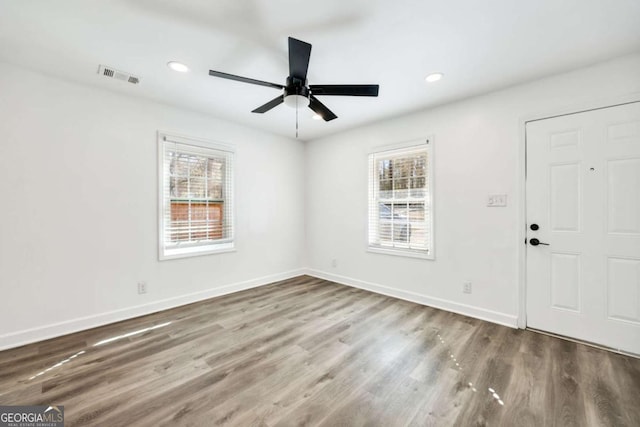 entrance foyer featuring visible vents, a healthy amount of sunlight, and wood finished floors