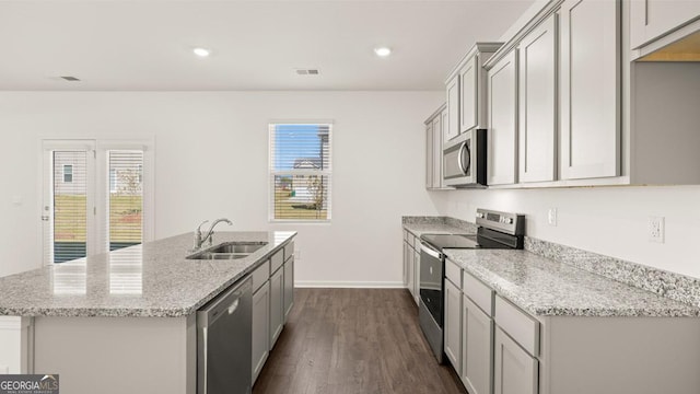 kitchen featuring appliances with stainless steel finishes, gray cabinets, a sink, and light stone countertops