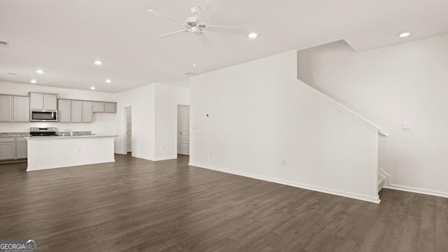 unfurnished living room with stairway, dark wood-style flooring, a ceiling fan, and recessed lighting