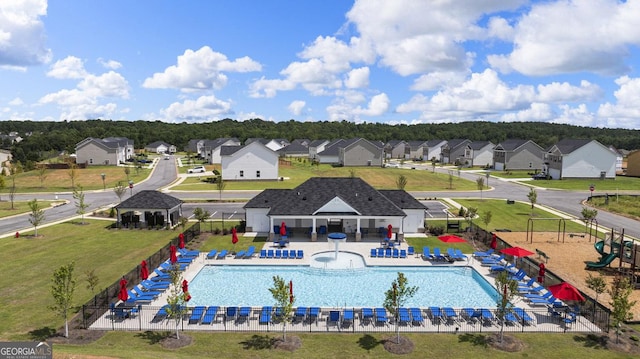 pool with a patio, fence, and a residential view