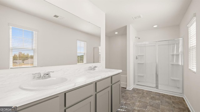 bathroom with a sink, visible vents, and a shower stall