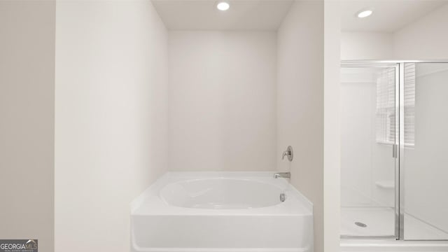 full bath with a stall shower, a bath, and recessed lighting