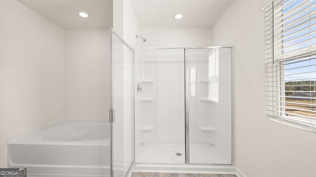 full bathroom with a stall shower, a garden tub, and recessed lighting