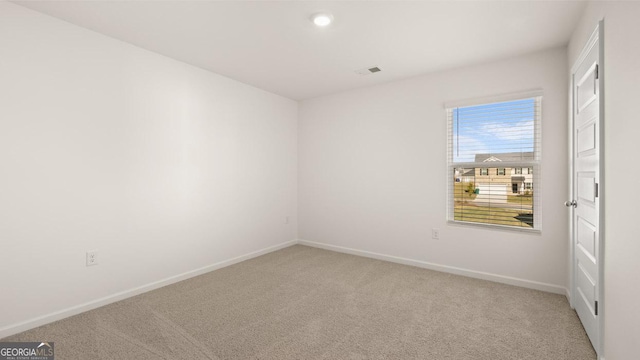 unfurnished room featuring carpet flooring, visible vents, and baseboards