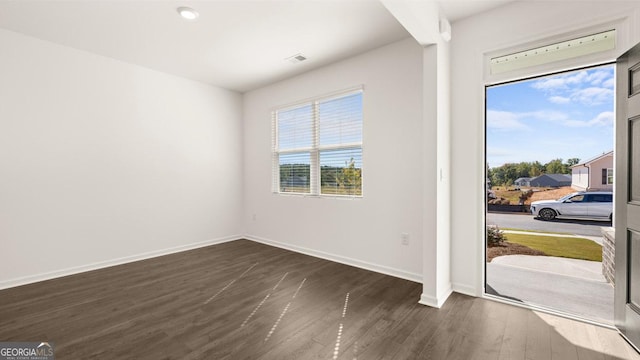 foyer with plenty of natural light, visible vents, baseboards, and dark wood-type flooring