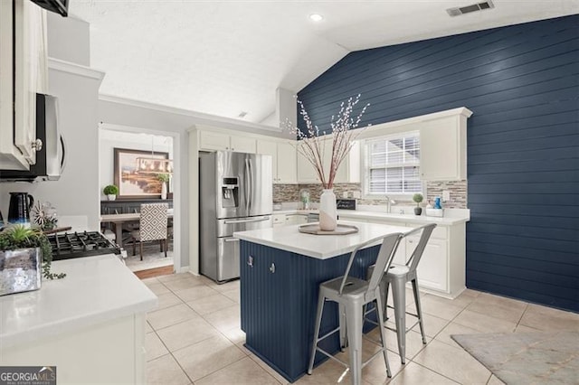 kitchen featuring light countertops, appliances with stainless steel finishes, white cabinetry, and a center island