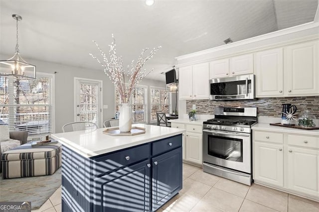 kitchen with white cabinetry, appliances with stainless steel finishes, light countertops, and decorative light fixtures