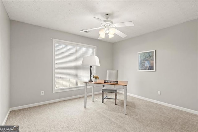 office featuring ceiling fan, baseboards, and light colored carpet