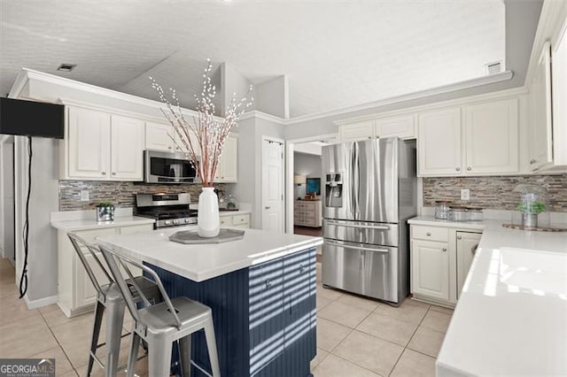 kitchen featuring stainless steel appliances, light countertops, and white cabinetry