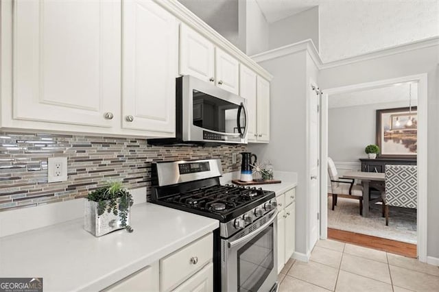 kitchen with white cabinets, decorative backsplash, stainless steel appliances, light countertops, and light tile patterned flooring