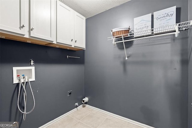 clothes washing area featuring a textured ceiling, hookup for a gas dryer, hookup for an electric dryer, washer hookup, and cabinet space