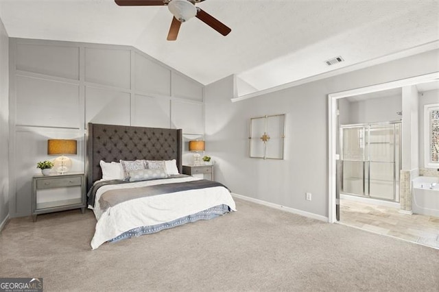 bedroom featuring lofted ceiling, light colored carpet, visible vents, ensuite bathroom, and baseboards