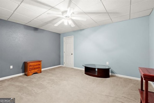 misc room with a paneled ceiling, carpet, and a ceiling fan