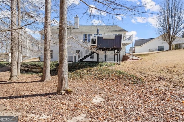 rear view of property with stairs and a chimney