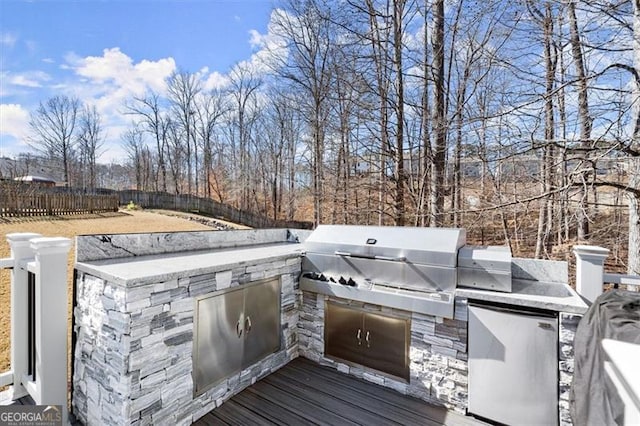 wooden deck with fence and area for grilling