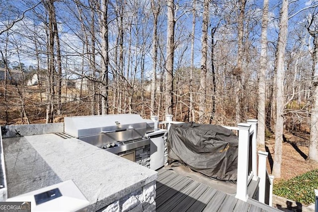 wooden terrace featuring an outdoor kitchen and area for grilling