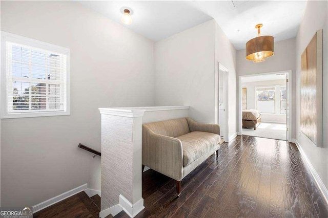 interior space featuring dark wood-type flooring, an upstairs landing, and baseboards