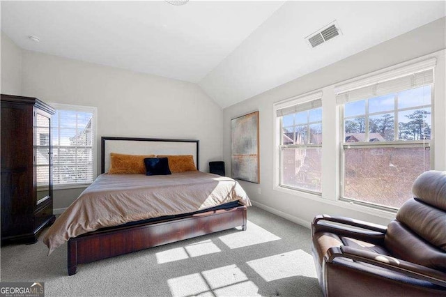 bedroom with vaulted ceiling, light carpet, visible vents, and baseboards