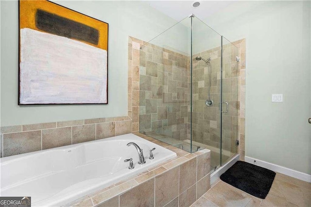 full bath featuring a stall shower, baseboards, a garden tub, and tile patterned floors