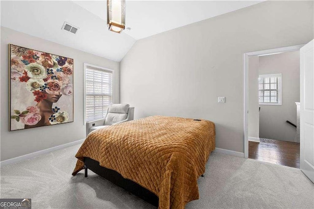 carpeted bedroom featuring lofted ceiling, visible vents, and baseboards