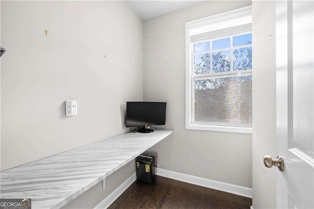 office space featuring dark wood-style flooring, built in study area, a wealth of natural light, and baseboards