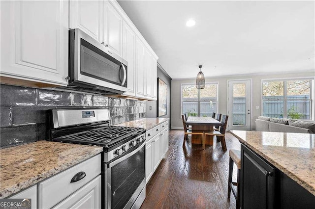 kitchen with light stone countertops, appliances with stainless steel finishes, and white cabinets