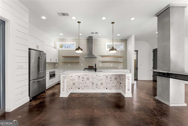 kitchen featuring white cabinetry, wall chimney exhaust hood, appliances with stainless steel finishes, and light countertops