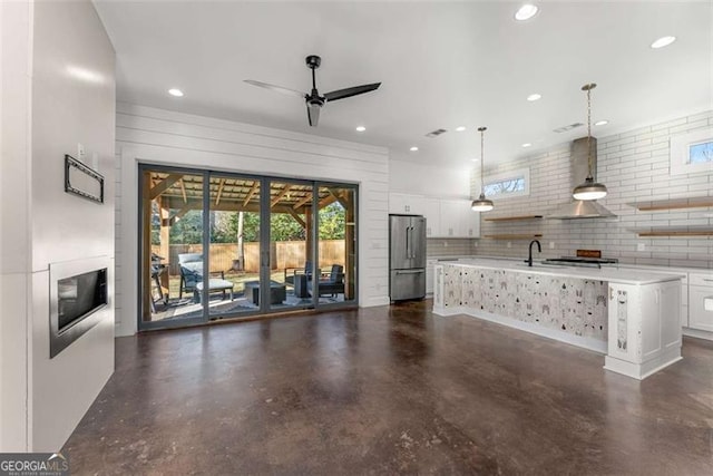 unfurnished living room featuring ceiling fan, recessed lighting, a sink, and finished concrete floors