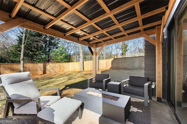 view of patio / terrace with a fenced backyard and an outdoor living space with a fire pit