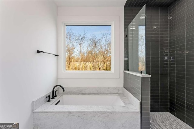 bathroom featuring tiled shower and a bath